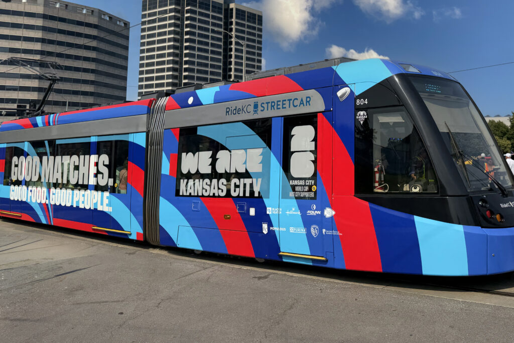 A RideKC Streetcar wrapped in Kansas City World Cup graphics travels through downtown Kansas City.